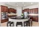 Gourmet kitchen showcasing dark wood cabinetry, stainless steel appliances, a central island, and counter seating at 75 Luce Del Sole # 3, Henderson, NV 89011