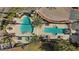 Overhead view of a unique pool with a hot tub, palm trees, and several tables with chairs surrounding it at 75 Luce Del Sole # 3, Henderson, NV 89011