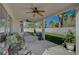 A covered patio with a ceiling fan, artificial turf, and decorative plants at 7650 Hartwell Dr, Las Vegas, NV 89123