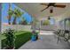 Backyard with artificial turf, a rock bed, a covered patio and palm trees at 7650 Hartwell Dr, Las Vegas, NV 89123