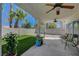 Inviting backyard featuring a covered patio with ceiling fans, lush artificial grass, and colorful plants at 7650 Hartwell Dr, Las Vegas, NV 89123