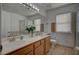 Well-lit bathroom featuring double sinks, shower with tiled accents, and updated fixtures at 7650 Hartwell Dr, Las Vegas, NV 89123