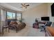 Spacious bedroom featuring a large window, a tufted chaise lounge, and a ceiling fan at 7650 Hartwell Dr, Las Vegas, NV 89123