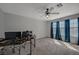 Bedroom with gray carpet, ceiling fan and windows with blue curtains, ideal for relaxation at 7650 Hartwell Dr, Las Vegas, NV 89123