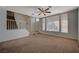 Bright living room featuring carpet flooring, a staircase, and large windows at 7650 Hartwell Dr, Las Vegas, NV 89123