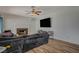 Spacious living room featuring a brick fireplace, ceiling fan, and wood flooring at 7650 Hartwell Dr, Las Vegas, NV 89123