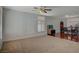 Spacious living room featuring carpet flooring, a ceiling fan, and natural light at 7650 Hartwell Dr, Las Vegas, NV 89123