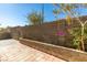 Private backyard area with a tall block wall providing seclusion, complemented by colorful flowers and desert landscaping at 7752 Orchard Wood Ct, Las Vegas, NV 89131