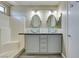 Bathroom boasts double sinks with glass basins and shower-tub combo, and a neutral color palette at 7752 Orchard Wood Ct, Las Vegas, NV 89131