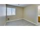 A bright, neutral bedroom with wood-look flooring, window, and a glimpse of the bathroom at 7752 Orchard Wood Ct, Las Vegas, NV 89131