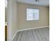 Neutral bedroom with light wood-look floors and a window, with a partial view of the bathroom at 7752 Orchard Wood Ct, Las Vegas, NV 89131