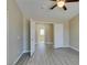 Neutral bedroom with gray, wood-look floors, open door, ceiling fan, and natural light at 7752 Orchard Wood Ct, Las Vegas, NV 89131