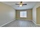 Bright bedroom with a ceiling fan, window, and gray wood-like flooring at 7752 Orchard Wood Ct, Las Vegas, NV 89131