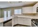 Modern kitchen with white cabinetry, quartz counters, stainless dishwasher, and a view to the french doors at 7752 Orchard Wood Ct, Las Vegas, NV 89131