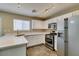 Well-lit kitchen featuring stainless steel appliances, white cabinets and stone countertops at 7752 Orchard Wood Ct, Las Vegas, NV 89131