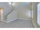 Bright living room with stairs, doorway, chandelier, and large windows with blinds at 7752 Orchard Wood Ct, Las Vegas, NV 89131