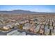 An aerial view of the property in a neighborhood filled with similarly styled homes under a blue sky with mountain views at 7970 Calito St, Las Vegas, NV 89166