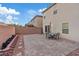 Spacious backyard patio with brick pavers, a dining table with umbrella, and a view of neighboring homes at 7970 Calito St, Las Vegas, NV 89166