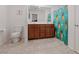 Bright bathroom with a double sink vanity, tiled floor, and fun pineapple shower curtain at 7970 Calito St, Las Vegas, NV 89166