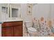 Functional bathroom featuring a wood vanity with a single sink, toilet, and decorative floral shower curtain at 7970 Calito St, Las Vegas, NV 89166