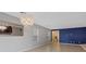 Bright living space with gray and blue walls, tile flooring, and an elegant chandelier at 7970 Calito St, Las Vegas, NV 89166