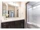 Modern bathroom featuring dark wood cabinets, marble countertops, and a glass-enclosed shower at 8012 Carpenter Creek Ave, Las Vegas, NV 89113