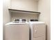 Laundry room features a full-size washer and dryer with an upper shelf for storage at 8012 Carpenter Creek Ave, Las Vegas, NV 89113