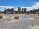 Garage and yard featuring sparse desert vegetation and bright sunny sky at 81 W Mesquite Ave, Pahrump, NV 89060