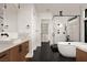 Modern bathroom featuring dual vanities, a soaking tub, a glass-enclosed shower, and stylish black fixtures at 826 Willits St, Las Vegas, NV 89138