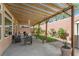 Covered patio area with outdoor seating, manicured grass, and a small storage shed at 8573 Silver Coast St, Las Vegas, NV 89139