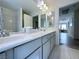 Bathroom vanity with dual sinks, white countertops, and modern fixtures, with views to the home's hallway at 8573 Silver Coast St, Las Vegas, NV 89139