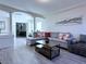 Bright living room with gray wood floors, neutral walls, and a comfortable gray sectional sofa at 8573 Silver Coast St, Las Vegas, NV 89139