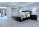 Bright primary bedroom with a decorative bed frame, dark wood accents, and wood-look floors at 8573 Silver Coast St, Las Vegas, NV 89139