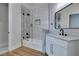 Modern bathroom featuring a glass enclosed shower-over-tub, white vanity, and sleek fixtures at 8649 Robinson Ridge Dr, Las Vegas, NV 89117