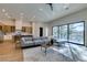 Stylish living room with a modern kitchen, a comfortable sofa, and views of the pool through expansive windows at 8649 Robinson Ridge Dr, Las Vegas, NV 89117