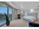 Bedroom featuring a tufted headboard bed, private balcony with wrought iron railing, and an accent chair at 9103 Alta Dr # 404, Las Vegas, NV 89145