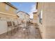 Cozy back patio area with brick pavers, wrought iron chairs and table, and secure fencing around the perimeter at 9278 Hainsworth Ave, Las Vegas, NV 89148