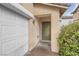 Exterior front door next to a closed garage door, greenery in the background at 9278 Hainsworth Ave, Las Vegas, NV 89148