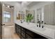 Dual vanity bathroom with dark wood cabinets, marble countertops, and modern fixtures at 1 Club Vista Dr, Henderson, NV 89052