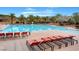 Large community pool with palm trees, lounge chairs, and a mountain backdrop at 1 Club Vista Dr, Henderson, NV 89052