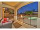 Covered back patio view featuring outdoor seating near a pool, waterfall, and fire pit area at 10233 Madison Grove Ave, Las Vegas, NV 89166