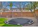 Fenced backyard featuring artificial grass, desert landscaping, and a trampoline at 10233 Madison Grove Ave, Las Vegas, NV 89166