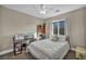 Well-lit bedroom with carpet, ceiling fan, and a window with neighborhood views at 10233 Madison Grove Ave, Las Vegas, NV 89166