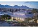 Stunning home featuring an outdoor pool, mountains in the background and professionally landscaped grounds at 10305 Orkiney Dr, Las Vegas, NV 89144