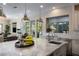 Bright, modern kitchen featuring a marble island with pendant lighting and stainless steel appliances at 10305 Orkiney Dr, Las Vegas, NV 89144