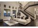 Elegant living room featuring a staircase, dark hardwood floors, and a large window with an outdoor view at 10305 Orkiney Dr, Las Vegas, NV 89144