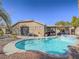 This backyard features a pool, spa, covered patio with seating, and lush landscaping at 10446 Abbotsbury Dr, Las Vegas, NV 89135