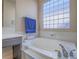 Bathroom with soaking tub, towel bar, and glass block window for natural light at 10446 Abbotsbury Dr, Las Vegas, NV 89135