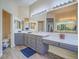 Bathroom featuring double sinks, vanity area, large mirrors, and wood-look tile floor at 10446 Abbotsbury Dr, Las Vegas, NV 89135