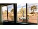 Backyard view through a large window, showcasing outdoor seating on a brick patio at 10528 Cogswell Ave, Las Vegas, NV 89134